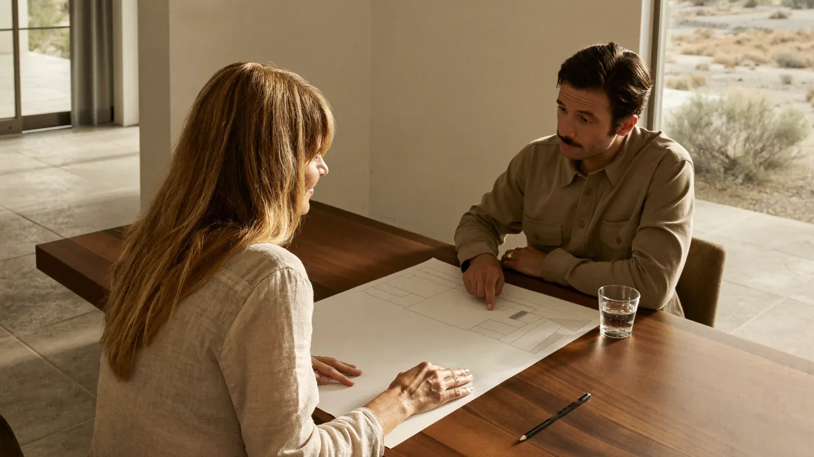 Homeowner and contractor reviewing remodel plans at a dining table