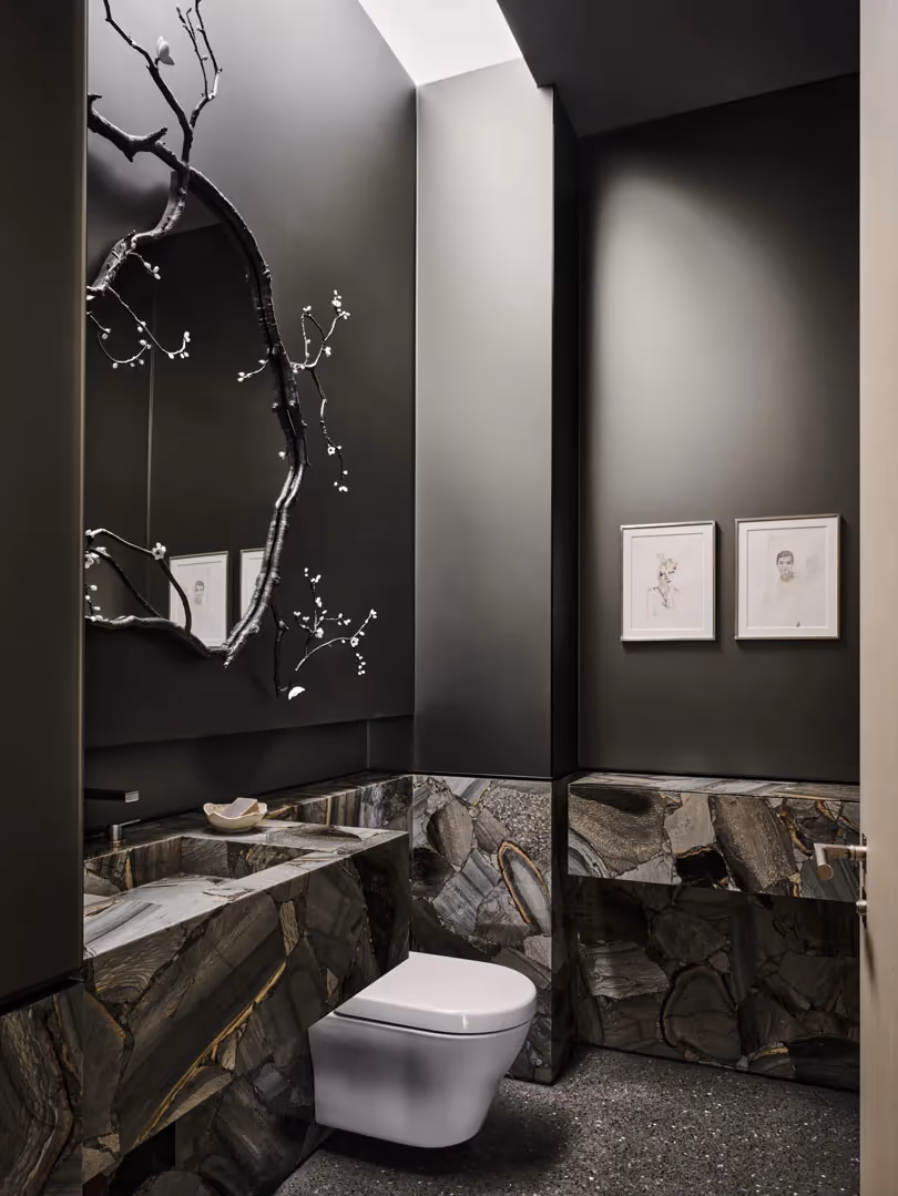 Dark powder room with a stone vanity wall and a wall-hung toilet
